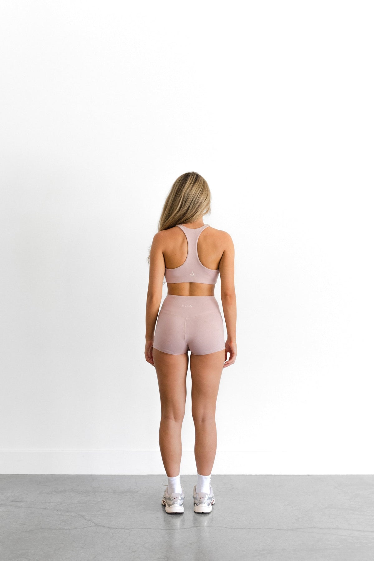 Back view of the blush SYLA Racer Short, seamless high-waist fit