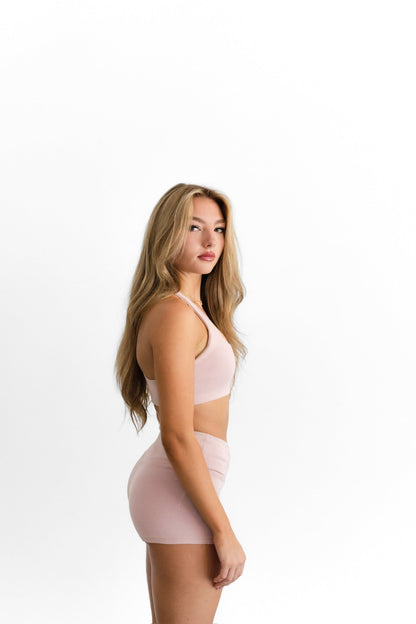 Side profile of the blush SYLA Racer Short, showing the high-waist fit and inseam