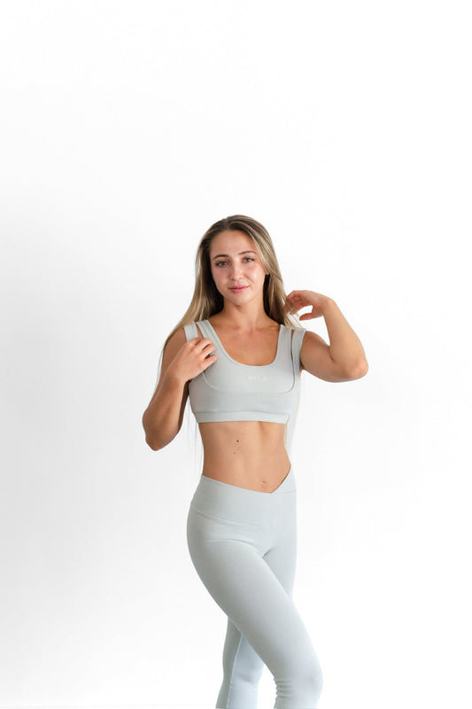 Close front view of the sage SYLA Sculpt Bra, showing the layered double-strap shoulder detail
