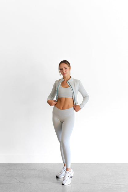 Full-length view of the sage SYLA Sculpt Set, cropped zip jacket layered over the Sculpt Bra and Leggings